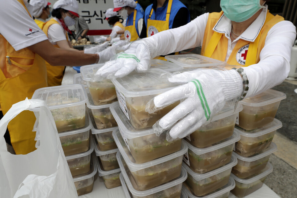 대한적십자사와 고려아연 직원들이 삼계탕을 담은 용기를 쌓아 겉절이, 참외와 같이 포장할 준비를 하고 있다. 김혜윤 기자