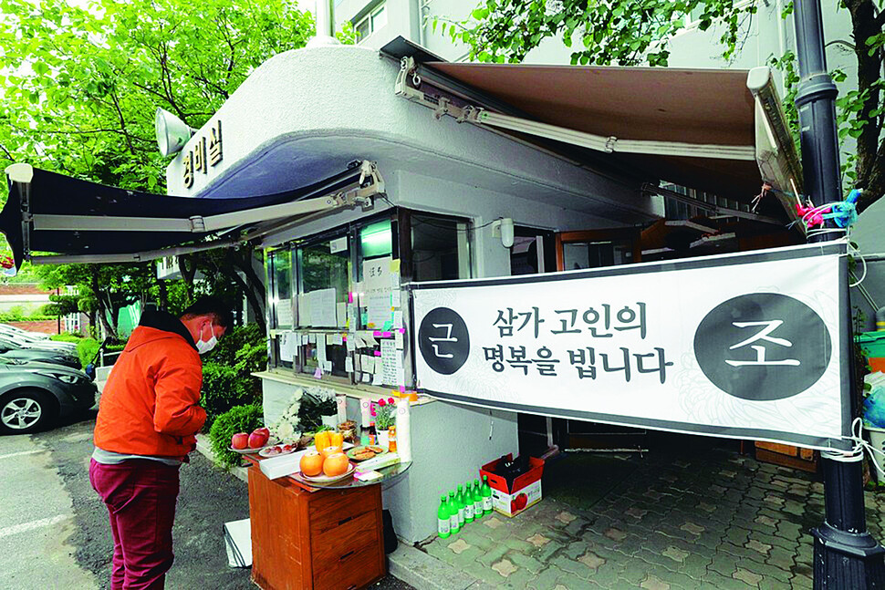 지난 5월12일 오전 서울 강북구 우이동 한 아파트 경비실 앞에서 열린 고 최희석 경비노동자 추모 긴급 기자회견에 앞서 시민들이 헌화를 하고 있다. 김봉규 선임기자 bong9@hani.co.kr