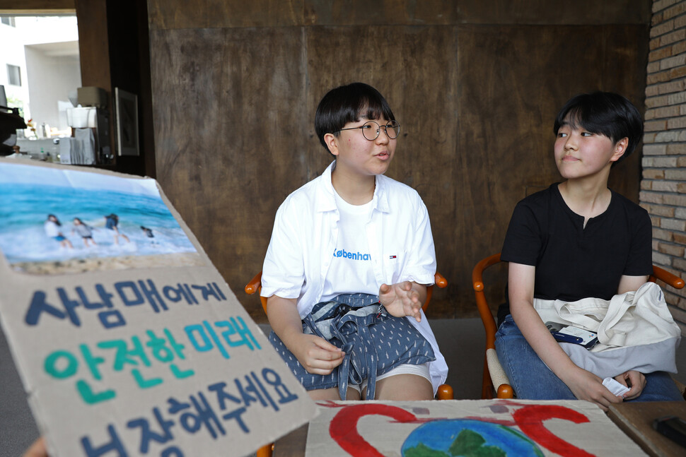 청소년기후행동 활동가인 윤해영(오른쪽), 윤현정씨가 지난 17일 낮 울산시 중구 태화강국가정원 근처 카페에서 기후위기에 관한 생각을 밝히고 있다. 이들 앞에는 울산대공원과 울산시청 앞 등에서 시위할 때 사용했던 피켓이 놓여 있다. 이 피켓들은 둘이 직접 만든 것이다. 울산/장철규 선임기자 chang21@hani.co.kr