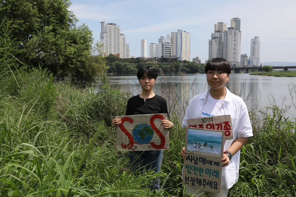 중학교 3학년 때부터 기후위기 운동을 해온 윤해영(왼쪽), 윤현정씨가 지난 17일 낮 울산시 중구 태화강 국가정원 강변에서 “10년 후 멸종위기종” 등 자신들이 만든 팻말을 들고 서 있다. 울산/장철규 선임기자 chang21@hani.co.kr