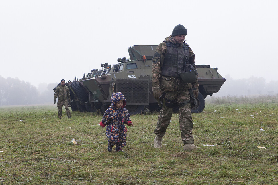 슬로베니아 군인의 보호를 받으며 걷고 있는 시리아 난민 아이. 전해리 사진가