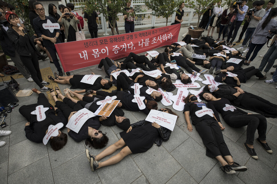 생리대 위해성 논란에 여성환경연대, 참여연대, 녹색연합, 한국여성민우회 등 시민사회단체 회원들이 2017년 9월5일 서울 종로구 정부서울청사 앞에서 ‘생리대 모든 유해성분 규명 및 역학조사 촉구 기자회견’을 열어 생리대를 몸에 붙이고 죽은 듯 바닥에 드러눕는 ‘다이인’(Die in) 행위극을 펼쳤다. 김성광 기자가 찍었다.