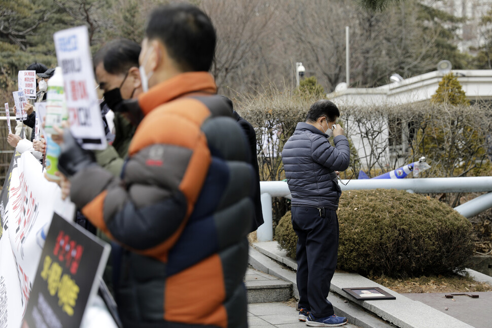 한 가습기 살균제 피해자 가족이 21일 낮 서울 서초구 서울중앙지방법원 앞에서 살균제 제조업체인 에스케이(SK)케미칼, 애경산업, 이마트의 임직원들에게 1심 무죄를 선고한 법원을 비판하는 기자회견 도중 부인의 영정사진을 내려놓고 눈물을 흘리고 있다. 김명진 기자