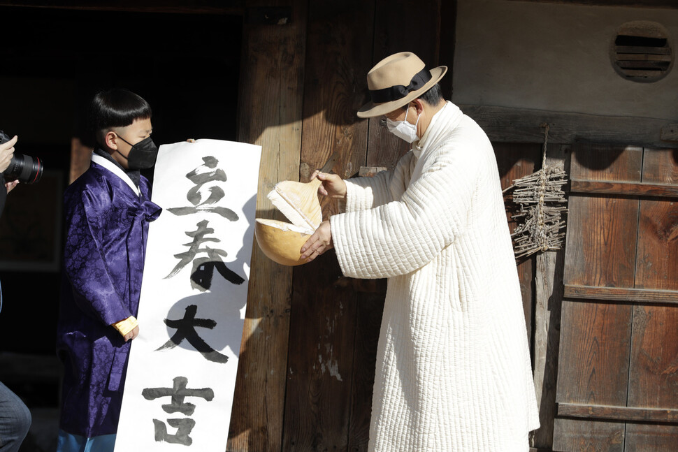 절기상 입춘인 3일 오전 서울 종로구 국립민속박물관 오촌댁에서 입춘첩 붙이기 행사 참가자들이 `입춘대길'(봄이 오니 크게 길함)이 적힌 입춘첩을 붙이려 대문에 풀을 바르고 있다. 김혜윤 기자