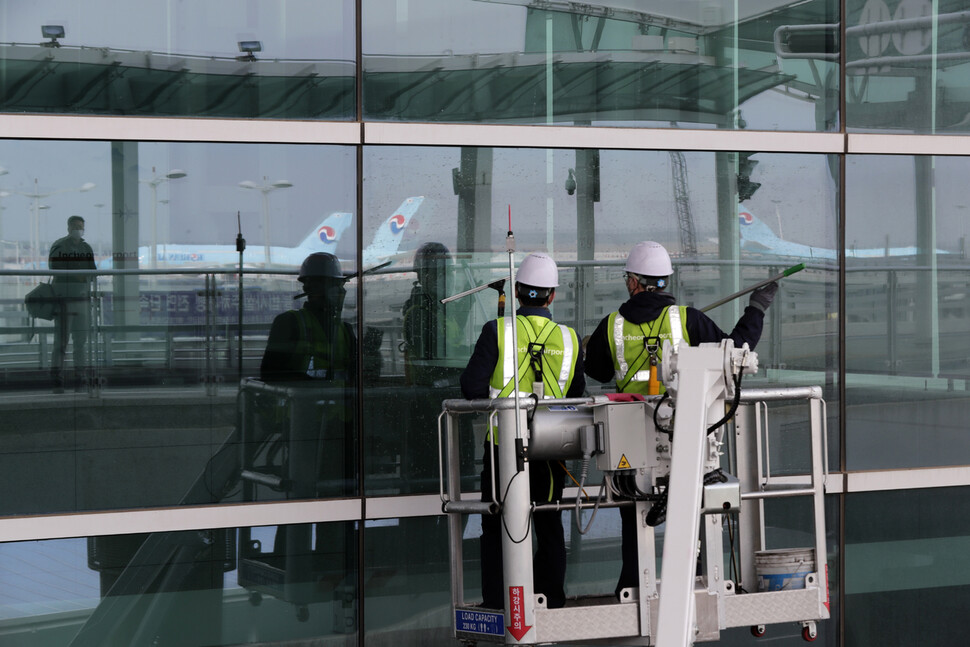 인천공항 직원들이 25일 오전 인천공항 제2여객터미널 외벽에서 고소차를 이용해 봄맞이 물청소를 하고 있다. 인천공항/김명진 기자