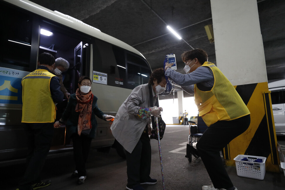 1일 오전 서울 중랑문화체육관에서 직원이 한 어르신에게 신내1동 명찰을 목에 걸어드리고 있다. 김혜윤 기자