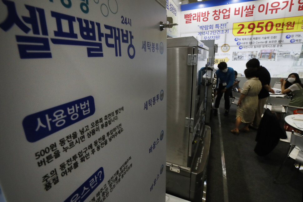 `2021 IFS 프랜차이즈 서울' 박람회장의 한 셀프빨래방 프랜차이즈 홍보관을 찾은 관람객들이 상담받고 있다. 이정아 기자