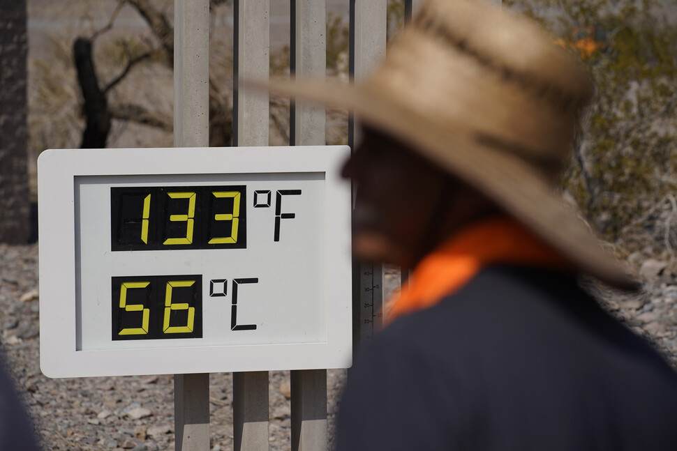 미국 서부가 폭염으로 펄펄 끓는 가운데 11일(현지시간) 캘리포니아주 데스밸리 국립공원에서 한 남성이 화씨 133도(섭씨 56도)를 가리키는 온도계를 바라보고 있다. AP/연합뉴스