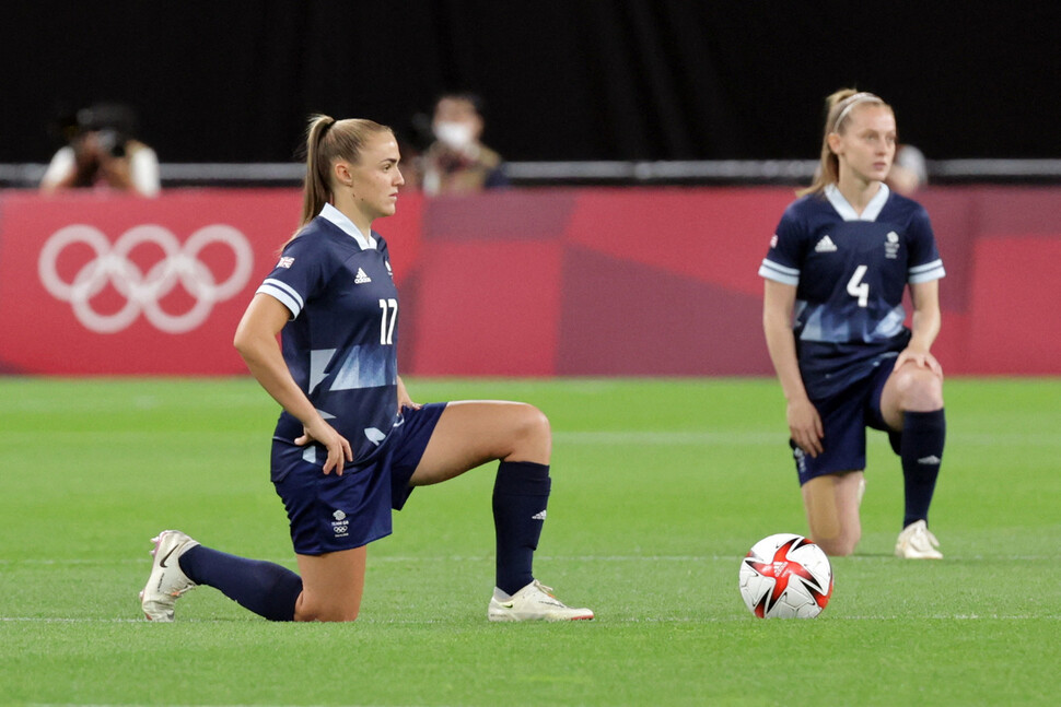 영국 여자 축구대표팀 선수들이 21일 일본 삿포로 삿포로돔에서 열린 E조 조별리그에 앞서 한쪽 무릎을 꿇은 모습. 경기 시작 전 ‘무릎꿇기’는 인종 차별에 항의하는 의미로 받아들여진다. 삿포로/AFP 연합뉴스