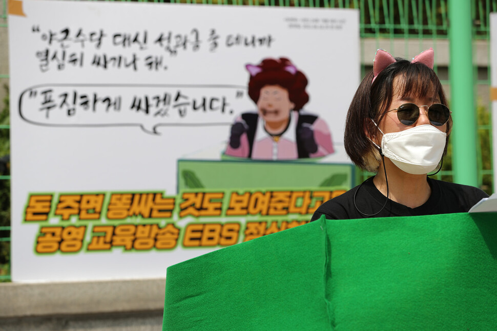 ‘정치하는 엄마들’ 활동가가 12일 오전 서울 양천구 목동 방송통신심의위원회가 있는 ＜교육방송＞ 애니메이션 `포텐독’ 24화 `개똥 테러 사건' 중 뽀글이가 기네스에게 야근수당을 받기로 하고 공개적으로 배변하는 장면을 재현하는 행위극하고 있다. 이종근 선임기자