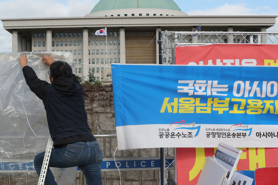 공공운수노조 아시아나케이오지부와 아시아니케이오 공대위가 12일 오전 고용노동부 국정감사가 열리고 있는 국회 앞에서 `부당해고’ 문제해결을 위해 국회가 나서줄 것을 촉구하는 필리버스터 및 손팻말 시위에 앞서 펼침막을 내걸고 있다. 김태형 기자