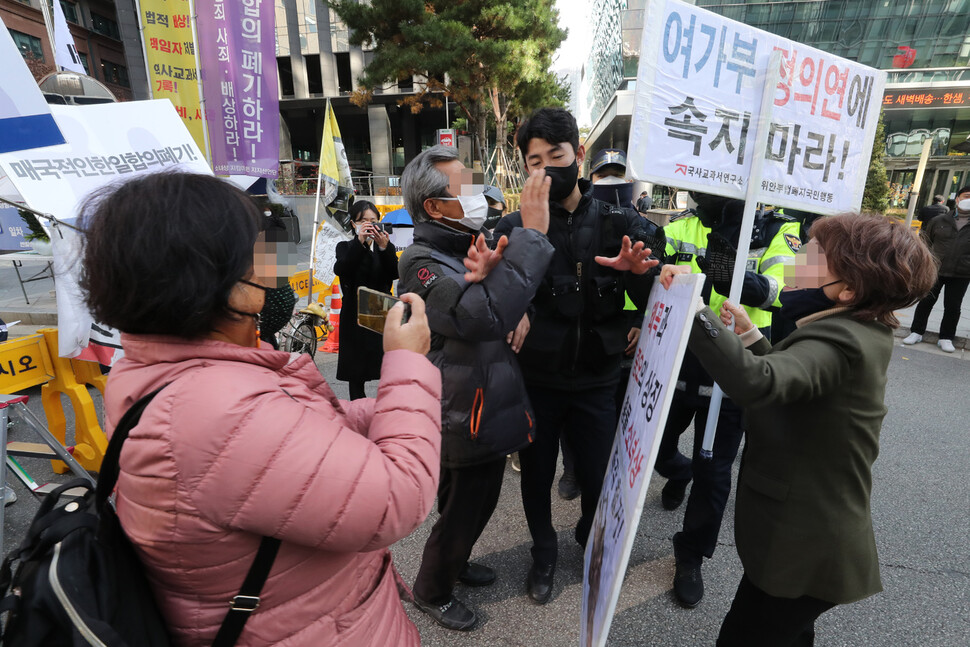 17일 오후 서울 종로구 옛 일본대사관 앞에서 보수단체 회원(오른쪽)이 `평화의 소녀상'앞에서 철야농성 중인 반일행동 회원에게 소녀상 철거를 주장하자 경찰이 이를 말리고 있다. 김태형 기자