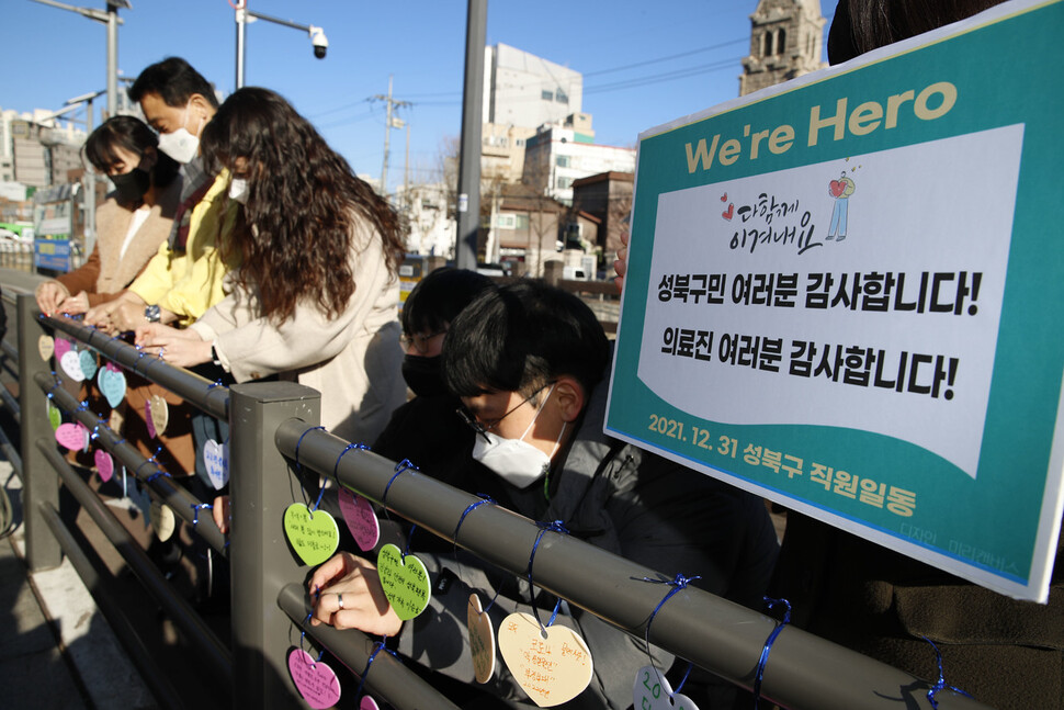 2021년 마지막날인 31일 오전 서울 성북구청 바람마당에 마련된 코로나19 임시선별검사소 인근에서 이승로 성북구청장(왼쪽 둘째)과 성북구청 직원들이 새해 소망을 적은 판을 걸고 있다. 김혜윤 기자