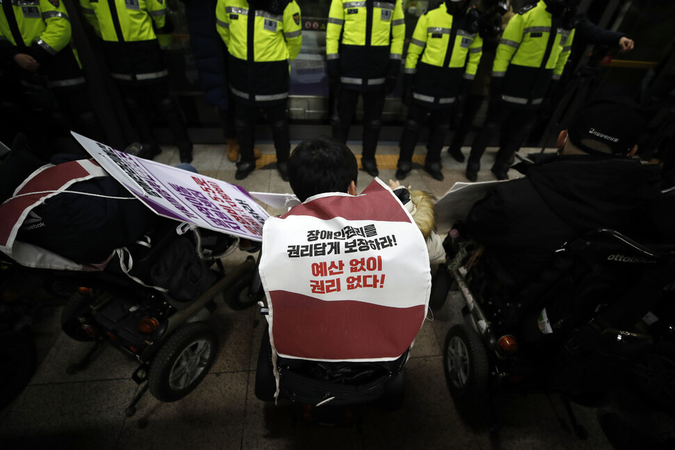 한 전국장애인차별철폐연대 활동가가 ‘장애인권리를 권리답게 보장하라! 예상 없이 권리 없다!’고 적힌 몸자보를 입고 있다. 김혜윤 기자