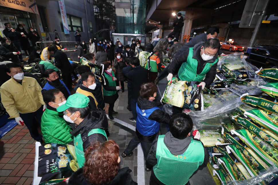 7일 아침 서울 성북구 월곡2동주민센터 앞에서 주민센터 직원, 예비군 동대 대원, 자원봉사 주민들이 12년째 `얼굴없는 천사'가 보내온 포장쌀 300포대를 트럭에서 내리고 있다. 김태형 기자