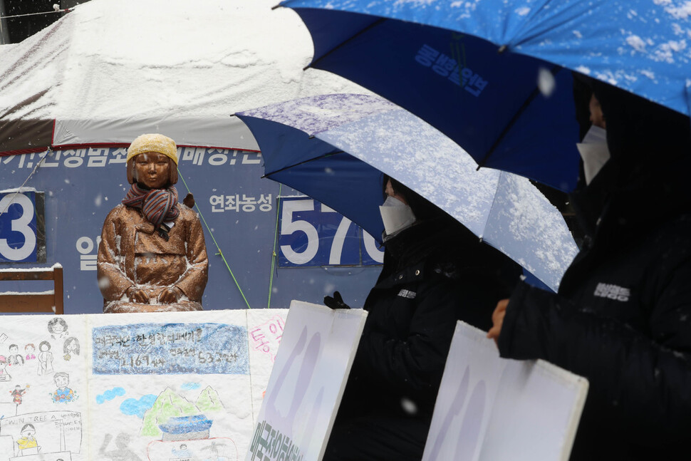 19일 낮 서울 종로구 옛 일본대사관 앞에서 일본군성노예제 문제해결을 위한 1527차 정기 수요시위가 열리는 동안 소녀상 위로 함박눈이 내리고 있다. 신소영 기자