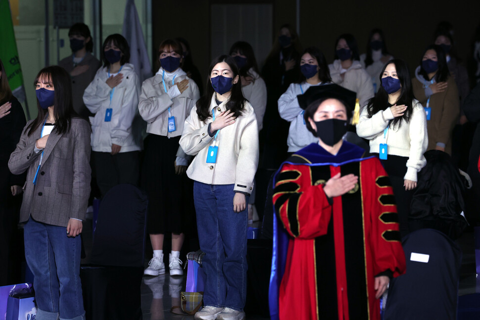 22일 오후 서울 용산구 숙명여자대학교에서 온·오프라인으로 열린 2022년 신입생 환영회에서 대면으로 참석한 신입생들이 국기에 대한 경례를 하고 있다. 연합뉴스