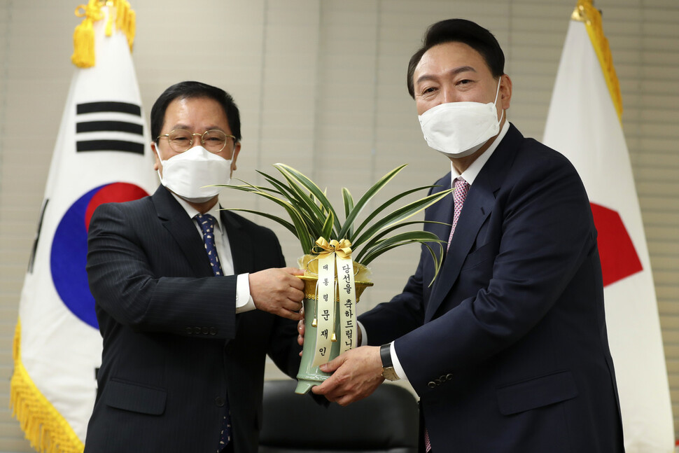 윤석열 대통령 당선자(오른쪽)가 10일 오후 서울 여의도 국민의힘 당사에서 유영민 대통령 비서실장에게 문재인 대통령의 축하난을 받고 있다. 공동취재사진