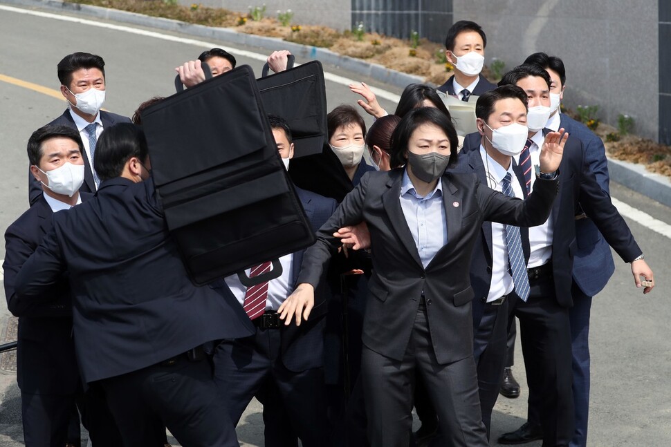 24일 오후 박근혜 전 대통령이 대구 달성군 사저에 도착해 대국민 담화문을 밝히던 중 갑자기 소주병이 날아들자 경호원들이 박 전 대통령을 에워싸고 있다. 연합뉴스