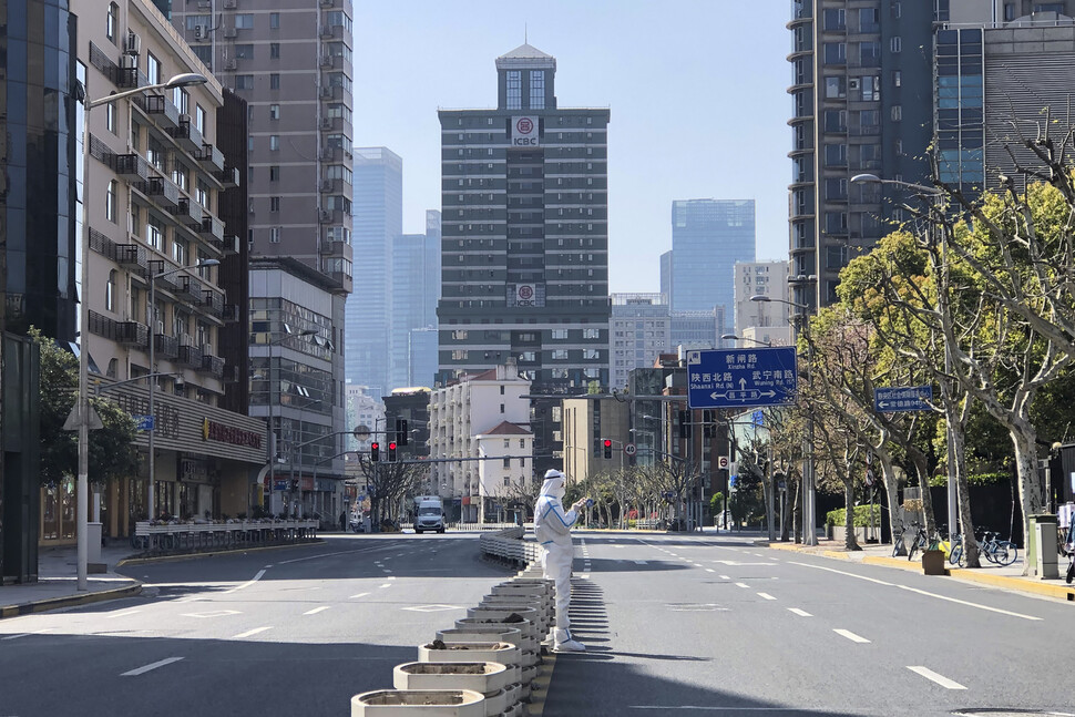 지난 4일(현지시각) 중국 상하이 서쪽 징안구의 봉쇄 지역에서 보호복을 입은 방역 요원이 텅 빈 거리 한가운데에 서 있다. 중국의 ‘경제수도'로 불리는 인구 2500만 명의 초거대 도시 상하이는 코로나19 확산 방지를 위해 지난 28일부터 무기한 봉쇄 중이다. 상하이/AP 연합뉴스