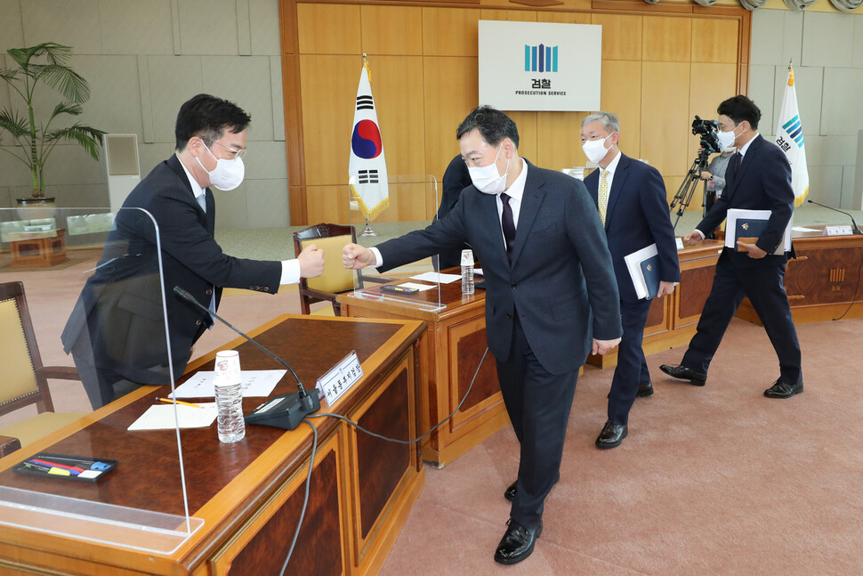 김오수 검찰총장(오른쪽 앞줄부터), 박성진 차장검사, 예세민 기획조정부장이 11일 오전 대검찰청에서 열린 전국 검사장 회의에서 심우정 서울동부지검장과 주먹인사를 하고 있다. 공동취재사진