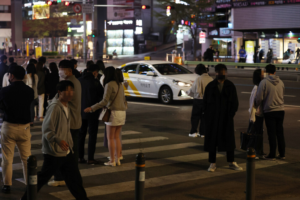 코로나19 방역을 위한 사회적 거리두기가 전면 해제된 18일 자정을 넘긴 시간 서울 강남역 인근에서 시민들이 택시를 잡기 위해 길거리에 서 있다. 오랜만에 늦은 시간까지 외부 활동을 즐기는 사람들이 늘면서 ''택시 대란''이 벌어졌다. 연합뉴스