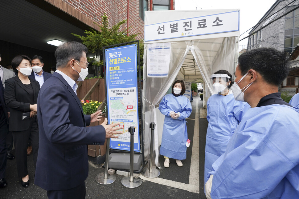 문재인 대통령이 25일 서울 종로구 보건소에서 코로나19 백신 4차 접종을 마친뒤 나서며 의료진을 격려하고 있다. 청와대사진기자단