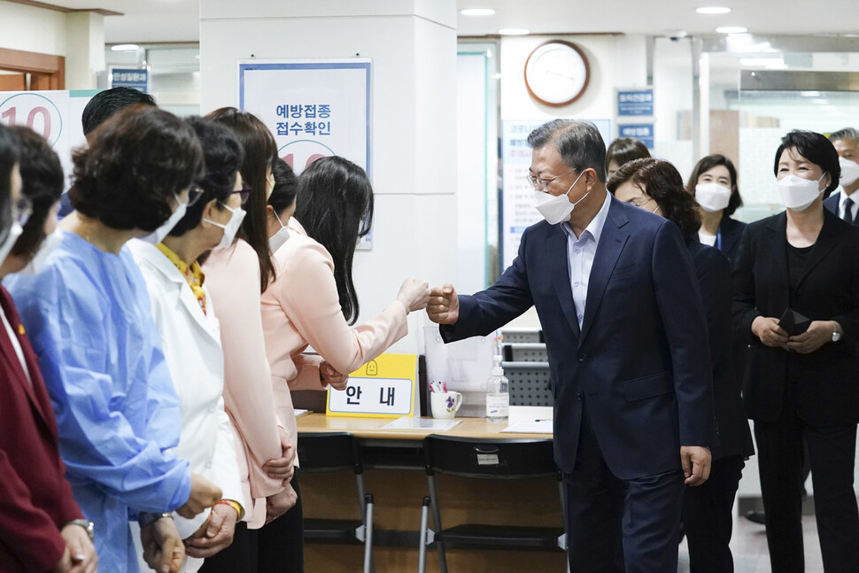 문재인 대통령이 25일 서울 종로구 보건소에서 코로나19 백신 4차 접종을 마친 뒤 나서며 의료진을 격려하고 있다. 청와대사진기자단