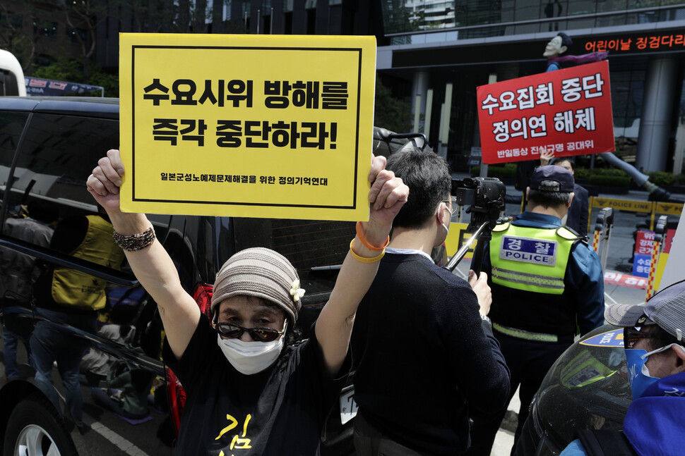 수요시위 참가자(왼쪽)과 보수단체 회원들이 경찰을 사이에 둔 채 손팻말을 들고 있다. 김명진 기자