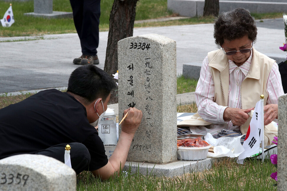 현충일을 하루 앞둔 5일 오전 서울 동작구 국립서울현충원 고 염영만 중사의 묘소에서 염 중사의 아들이 바래진 묘비 글자에 색을 칠하고 있다. 백소아 기자 thanks@hani.co.kr