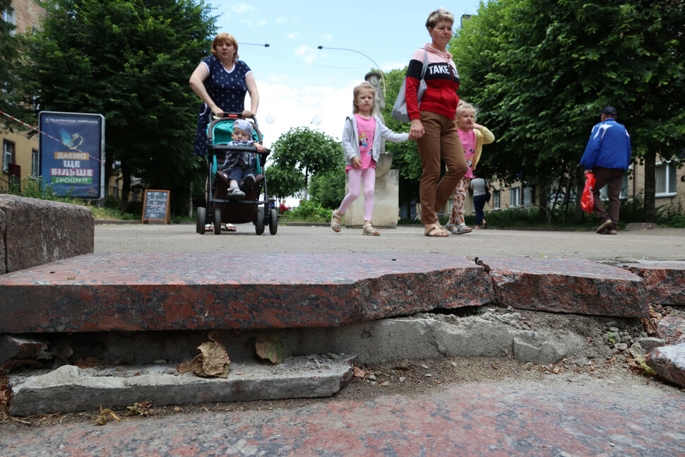 러시아군의 점령 때 깨진 우크라이나 부차 시장 인근 계단 뒤로 어린이들의 손을 잡고 걸어가는 주민들이 보이고 있다. 부차/김혜윤 기자