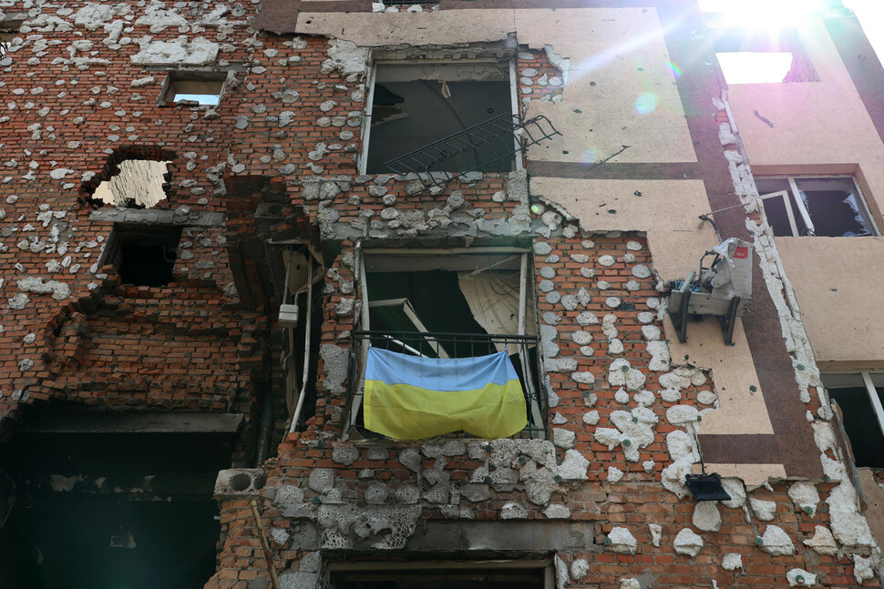 18일(현지시각) 오후 우크라이나 이르핀의 한 아파트 단지와 그 일대가 러시아군의 공격으로 폐허가 되어 있다. 무너진 창문 난간에 우크라이나 국기가 걸려 있다. 이르핀/김혜윤 기자