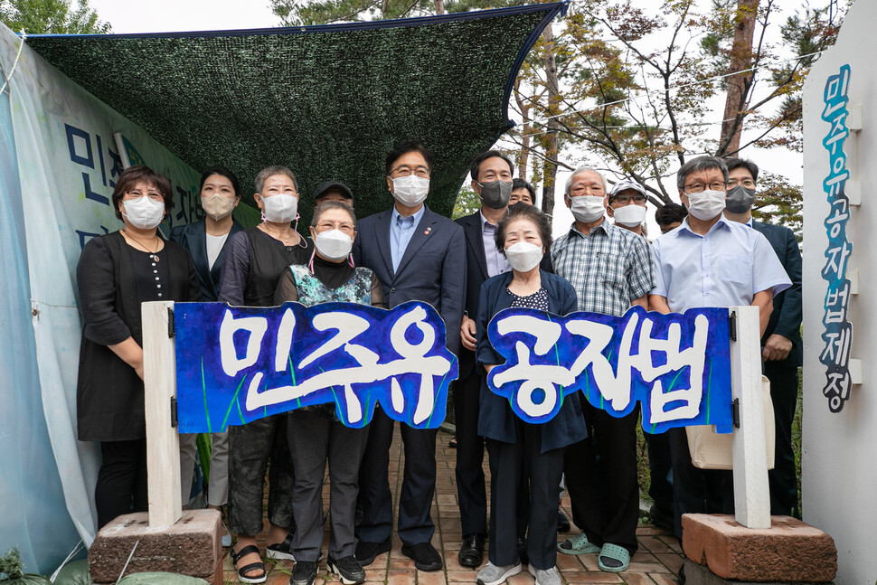 더불어민주당 우상호 비상대책위원장과 우원식 의원이 지난 21일 오전 서울 여의도 국회 정문 앞에서 '민주유공자법 제정'을 촉구하며 9개월째 농성 중인 전국민족민주유가족협의회(유가협)와 민주유공자법제정추진단의 천막농성장을 방문해 유족들과 기념촬영을 하고 있다. 국회사진기자단