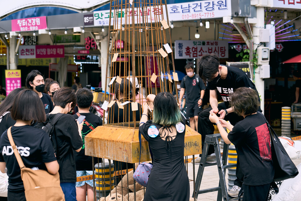 말복인 15일 경기 성남시 모란시장 앞에서 동물해방물결 활동가와 시민들이 ‘2022 복날 추모행동’ 기자회견을 열고 건강원 앞 거리에 설치된 ‘복날 추모탑’에 추모의 메시지를 걸고 있다. 동물해방물결 제공