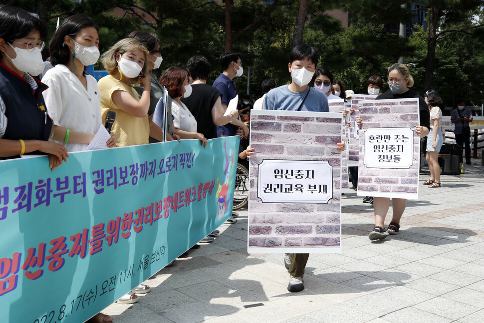 17일 오전 서울 종로구 보신각 앞에서 열린 모두의 안전한 임신중지를 위한 권리 보장 네트워크 출범식에서 행위극 담당 활동가들이 지금까지 임신중지 권리 보장을 막은 요소들을 적은 팻말을 들고 걸어나오고 있다. 김혜윤 기자