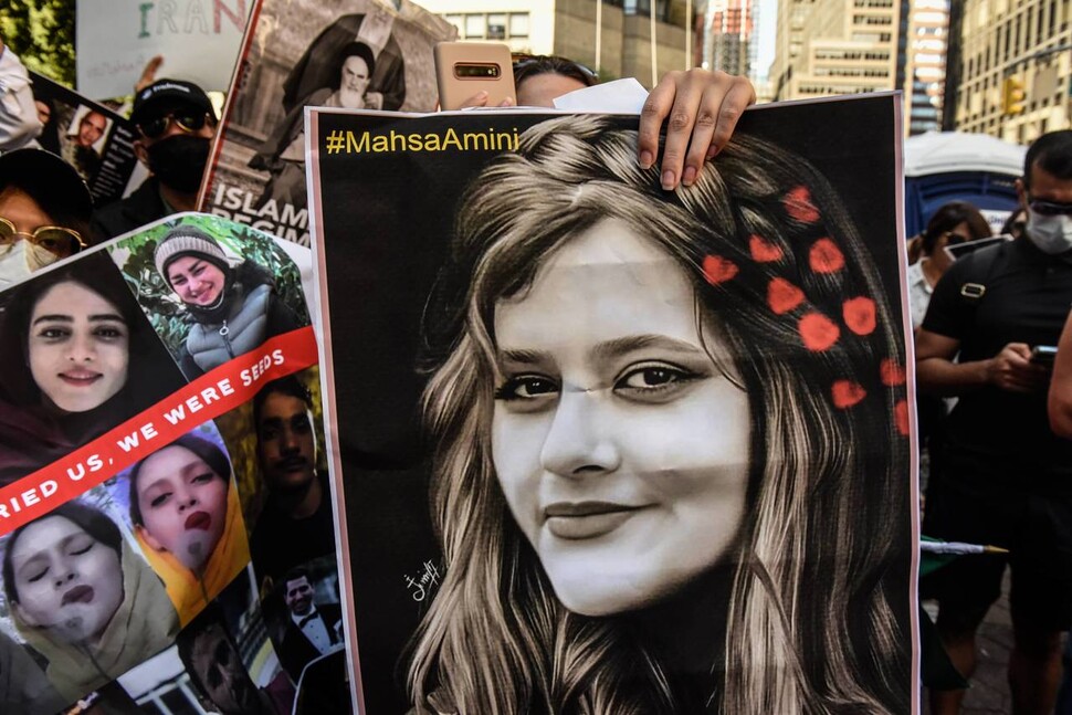 지난 21일 미국 뉴욕 유엔본부 앞에서 에브라힘 라이시 이란 대통령에게 항의하는 시위가 발생했다. 시위대는 히잡을 느슨하게 착용했다는 이유로 체포돼 숨진 22살 여성 아미니의 사진을 높게 들었다. AFP 연합뉴스