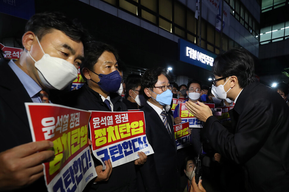 더불어민주당 박범계 윤석열정권정치탄압대책위원장(왼쪽 셋째)과 의원들이 19일 저녁 서울 여의도 당사 들머리에서 민주연구원 압수수색에 나선 검찰 관계자들을 막아선 채 이야기를 나누고 있다. 박종식 기자 anaki@hani.co.kr