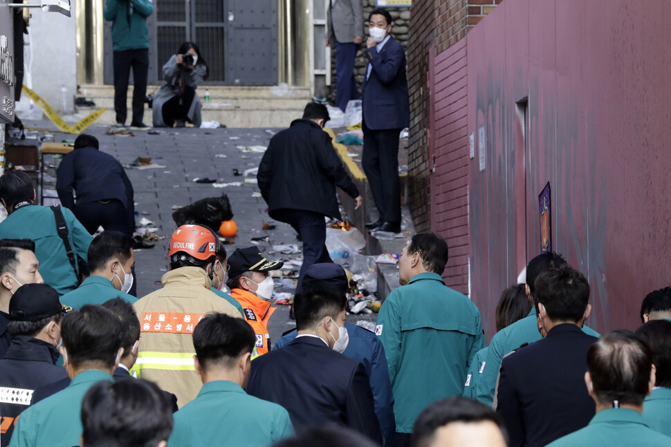 서울 용산 이태원 참사 현장을 찾은 윤석열 대통령이 30일 오전 현장을 살펴보는 동안 경호 관계자들이 바닥에 놓여진 물품들을 치우고 있다. 김명진 기자