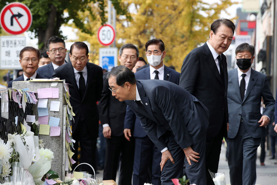 윤석열 대통령과 함께 1일 서울 용산구 이태원역 1번 출구 앞 이태원 참사 추모 공간을 방문한 한덕수 국무총리가 헌화한 뒤 시민들의 추모 메시지를 읽고 있다. 대통령실통신사진기자단