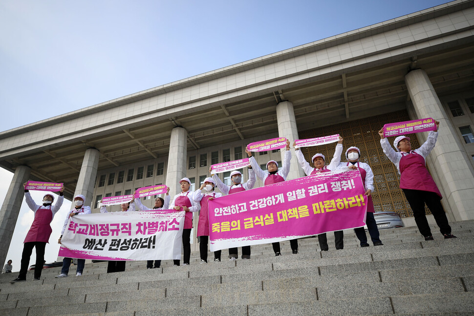 학교 급식실에서 일하는 노동자들이 국회 본관 들머리에서 학교급식실 폐암 산재 대책 마련과 인력충원 및 복리후생비 차별 해소 예산 편성을 요구하며 펼침막을 들고 구호를 외치고 있다. 김혜윤 기자