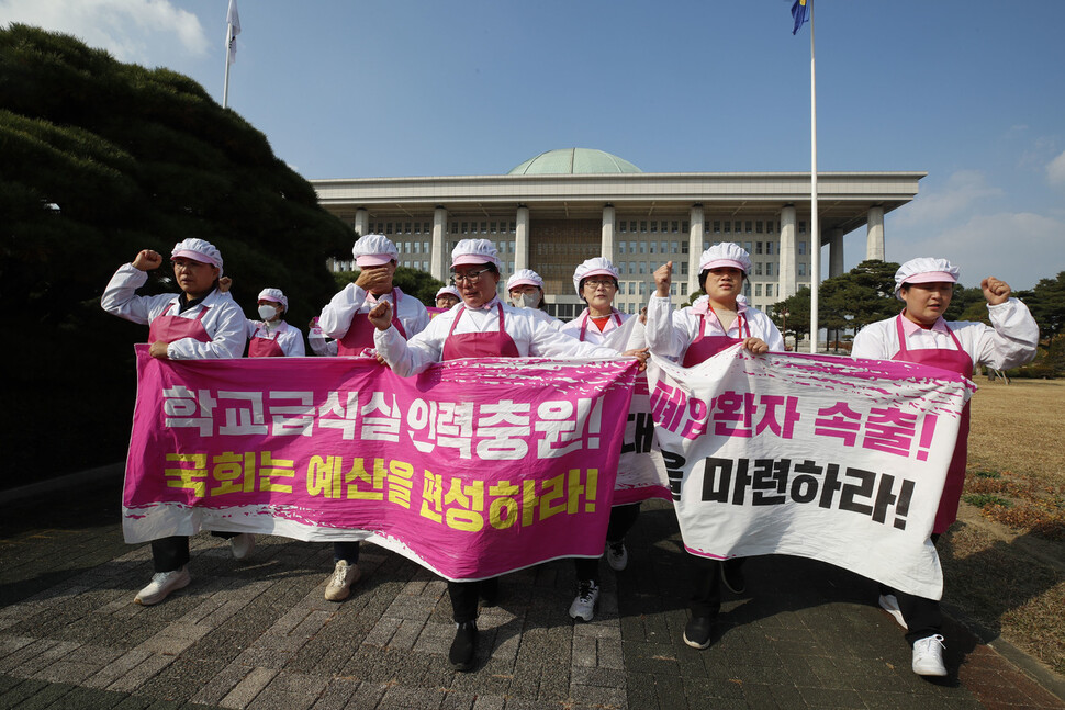 학교 급식 노동자들이 학교급식실 폐암 산재 대책 마련과 인력충원 및 복리후생비 차별 해소 예산 편성을 요구하며 펼침막을 들고 구호를 외치며 국회를 나서고 있다. 김혜윤 기자