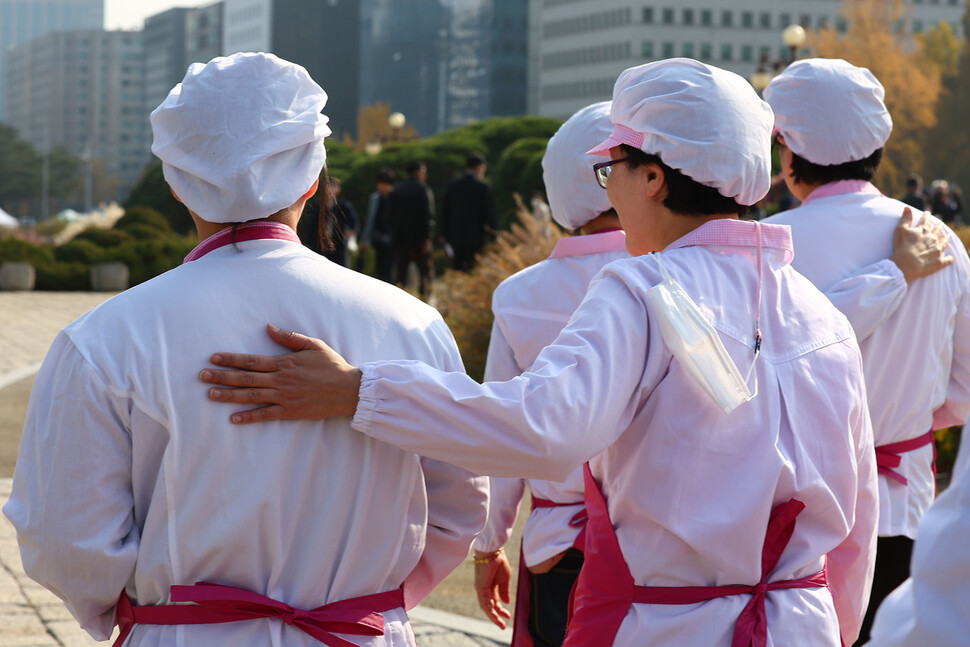 학교 급식실 노동자들이 기습시위를 마친 다음 서로를 다독이며 국회를 나서고 있다. 김혜윤 기자