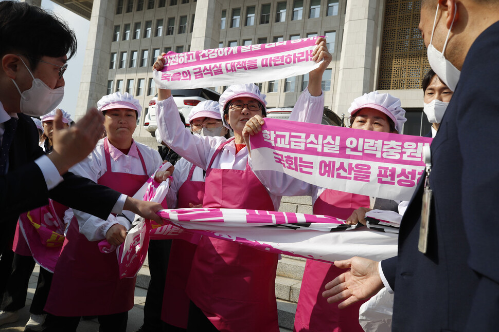 학교 급식실에서 일하는 전국학교비정규직노동조합 조합원들이 8일 낮 국회 본관 들머리에서 학교급식실 폐암 산재 대책 마련과 인력충원 및 복리후생비 차별 해소 예산 편성을 요구하며 펼침막을 들고 구호를 외치다 국회 보안 담당관들에게 저지당하고 있다. 김혜윤 기자 unique@hani.co.kr