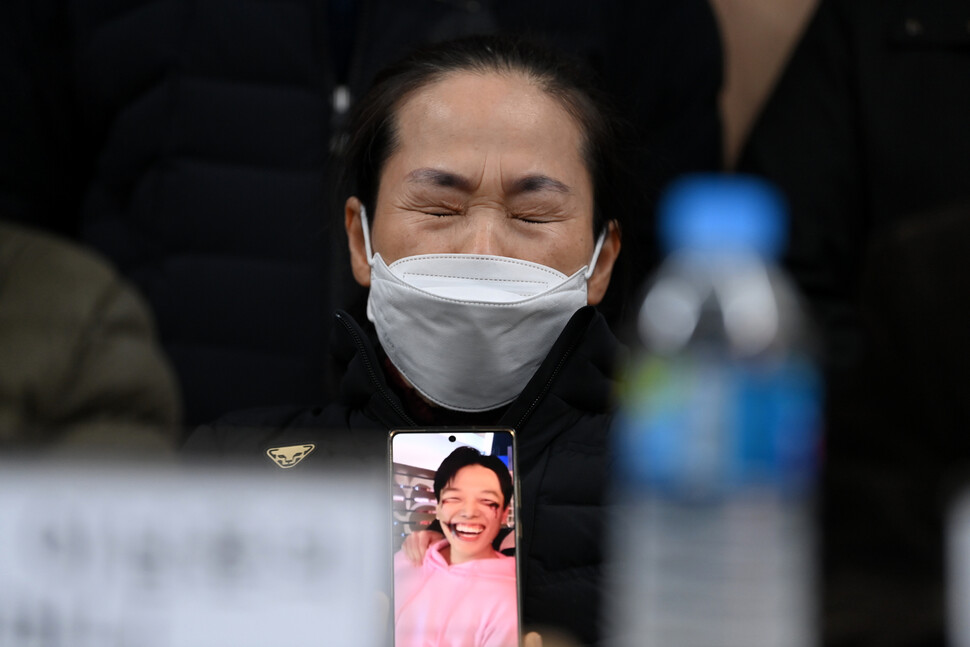 이태원 참사 유가족이 22일 오전 서울 서초구 민주사회를 위한 변호사모임(민변) 대회의실에서 열린 입장발표 기자회견에서 할로윈 분장을 한 채 활짝 웃던 자녀의 생전 사진을 든 채 눈물을 흘리고 있다. 공동취재사진