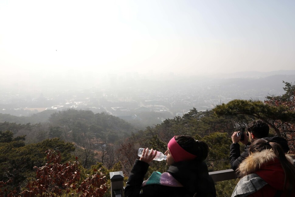 8일 서울 북악산 청와대전망대에서 미세먼지와 황사로 도심이 뿌옇게 보이는 가운데 한 등산객이 물을 마시고 있다. 김혜윤 기자