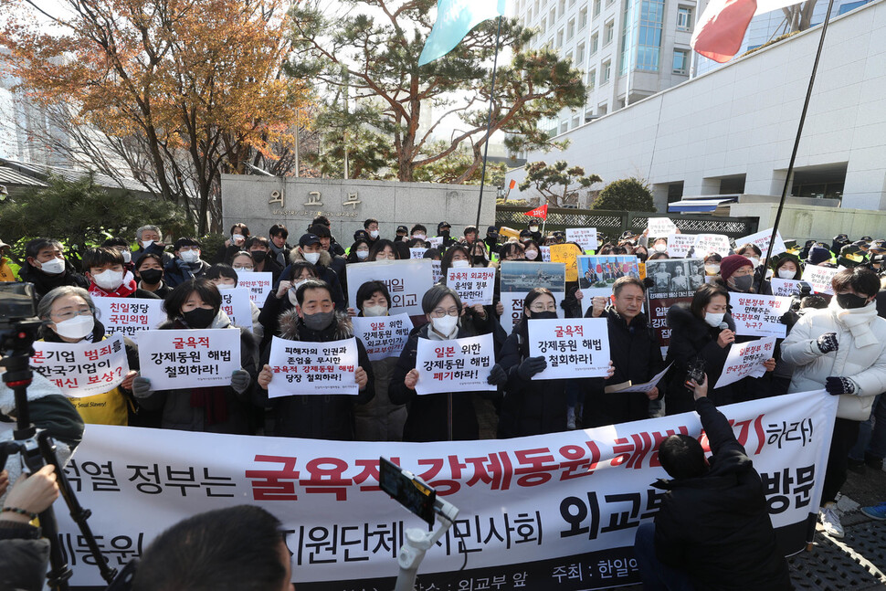 18일 서울 종로구 옛 주한일본대사관 앞 평화의소녀상 인근 평화로에서 일본군성노예제 문제해결을 위한 1579차 정기수요시위를 마친 참가자들이 외교부 앞에서 굴욕적 강제동원 해법 철회를 촉구하는 구호를 외치고 있다.강창광 선임기자