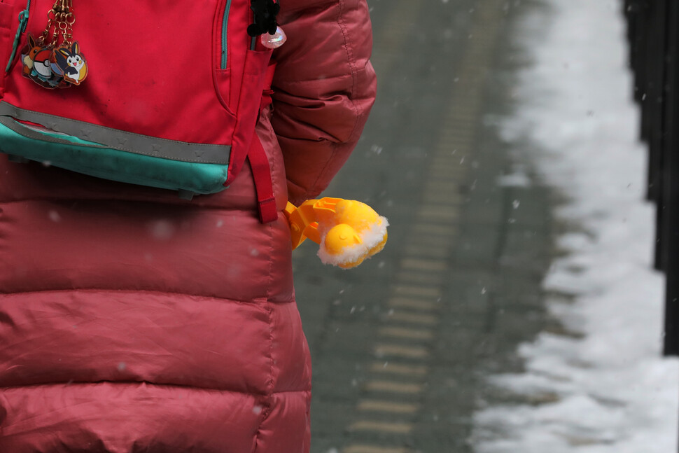 26일 오전 서울 영등포구 영중초등학교 학생이 눈오리를 주머니에 넣은 채 등교하고 있다. 김혜윤 기자