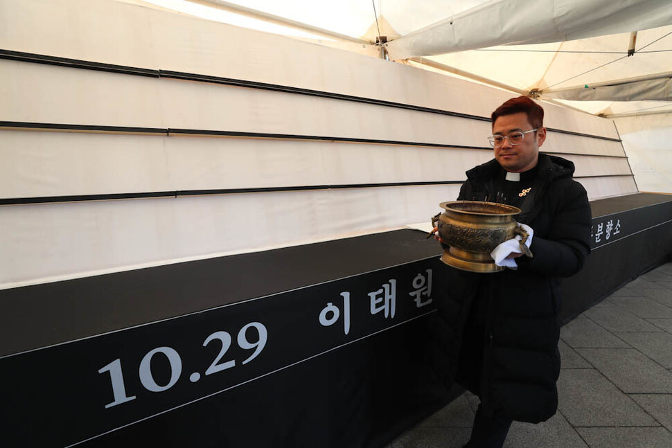 10·29 이태원 참사 유가족협의회와 시민대책회의가 14일 오후 서울 용산구 녹사평역 ‘이태원 참사 희생자 합동분향소’ 앞에서 기자회견을 열어 이곳 분향소를 이전해 서울광장 분향소와 통합·운영한다고 밝힌 뒤, 시민대책회의 공동운영위원장인 자캐오 신부가 향로를 옮기고 있다. 김정효 기자