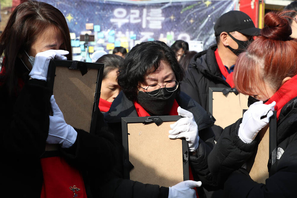 이태원 참사 유가족들이 14일 오후 서울 용산구 녹사평역 ‘이태원 참사 희생자 합동분향소’에 있던 희생자 영정을 건네 받은 뒤 가슴에 품고 있다. 김정효 기자