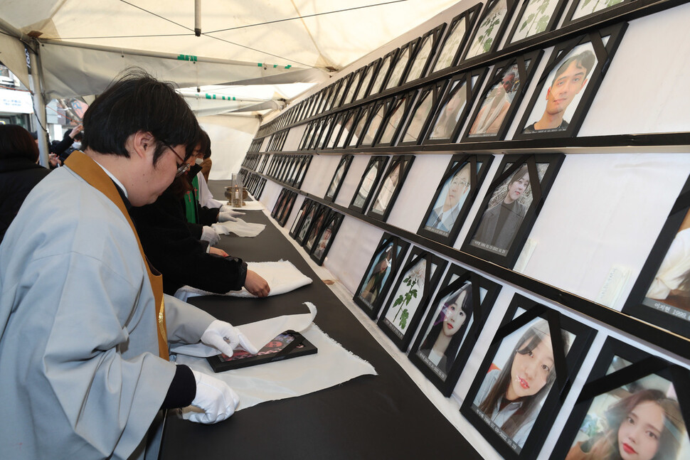 10·29 이태원 참사 유가족협의회와 시민대책회의가 14일 오후 서울 용산구 녹사평역 ‘이태원 참사 희생자 합동분향소’ 앞에서 기자회견을 열어 이곳을 이전해 서울광장 분향소와 통합 운영한다고 밝힌 뒤, 종교인들이 희생자 영정을 흰 천으로 감싸고 있다. 유가족들은 서울광장 분향소를 중심으로 지속적인 진상규명 촉구 활동을 이어가겠다고 밝혔고, 서울시는 15일 오후 1시까지 서울광장 분향소를 자진 철거해달라고 요청했다. 김정효 기자 hyopd@hani.co.kr